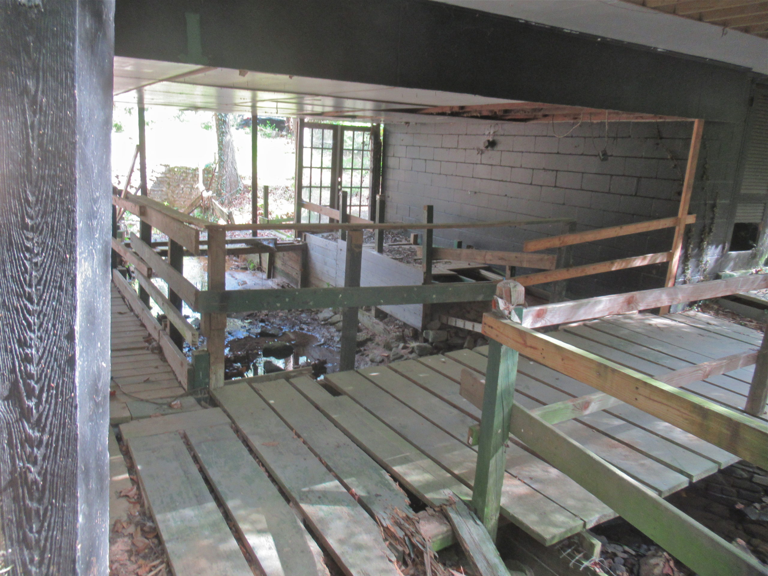 Unstable bridge over creek under house